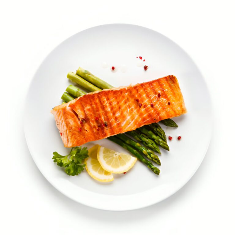 Grilled salmon fillet served with asparagus and lemon slices on a white plate.