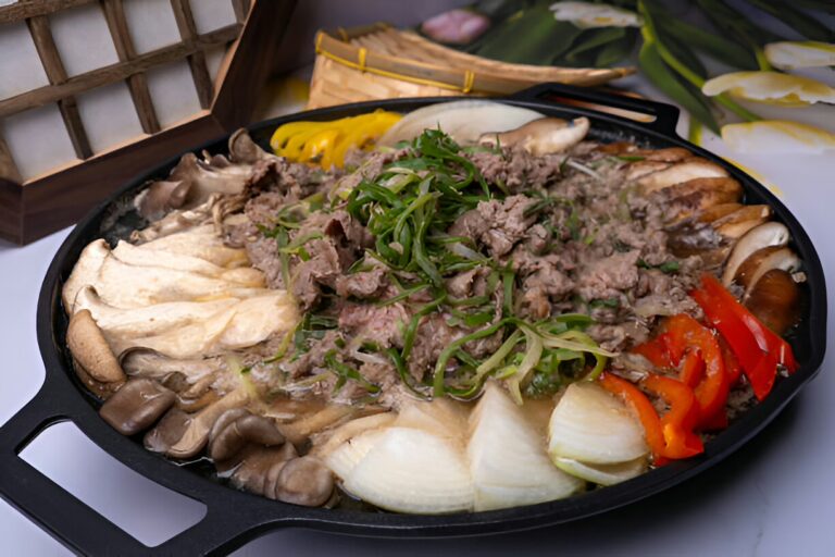 A hot pot dish with various types of mushrooms, sliced beef, and fresh vegetables, served in a black cast iron pot.