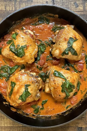 Skillet Chicken Thighs Creamy Tomato Basil Spinach Sauce taken with iphone 15 pro max --iw 2 --ar 4:5 --v 6.1 --raw