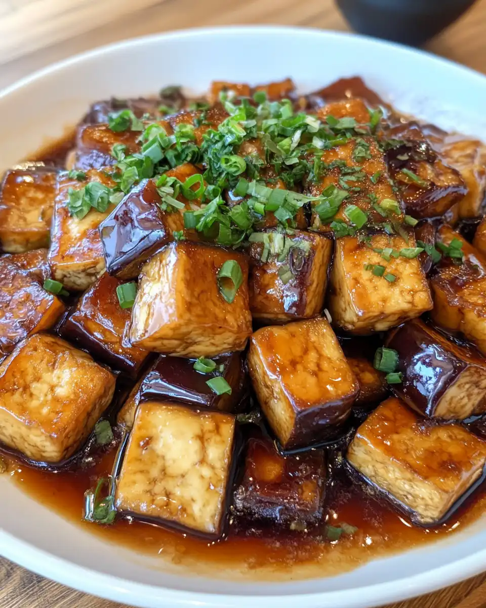 Plated eggplant and tofu adobo with rice, showing final serving