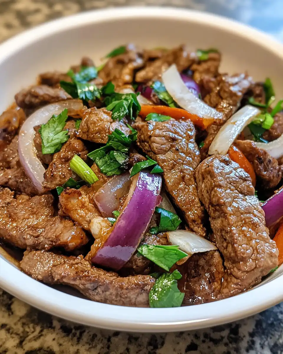 Serving plate of pepper steak with onions and sauce served fresh