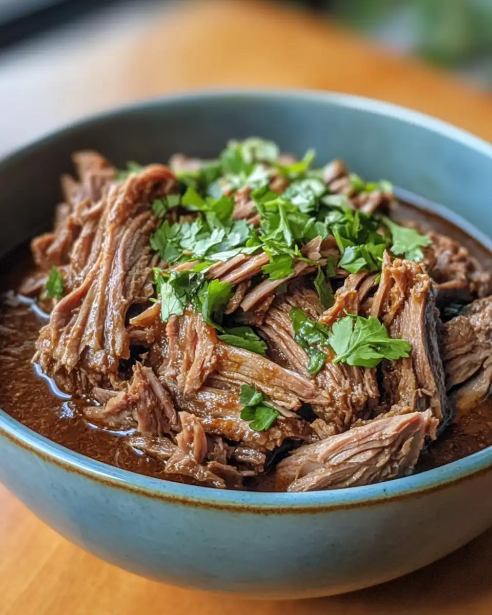 Ingredients for barbacoa including beef chunks, garlic, chipotles and spices
