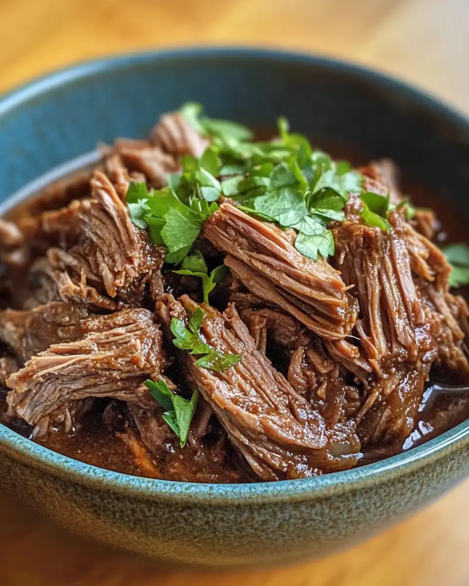 Pressure cooker barbacoa simmering with steam in kitchen