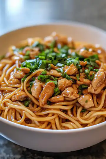 sticky garlic chicken noodles taken with iphone 15 pro max --iw 2 --ar 4:5 --v 6.1 --raw
