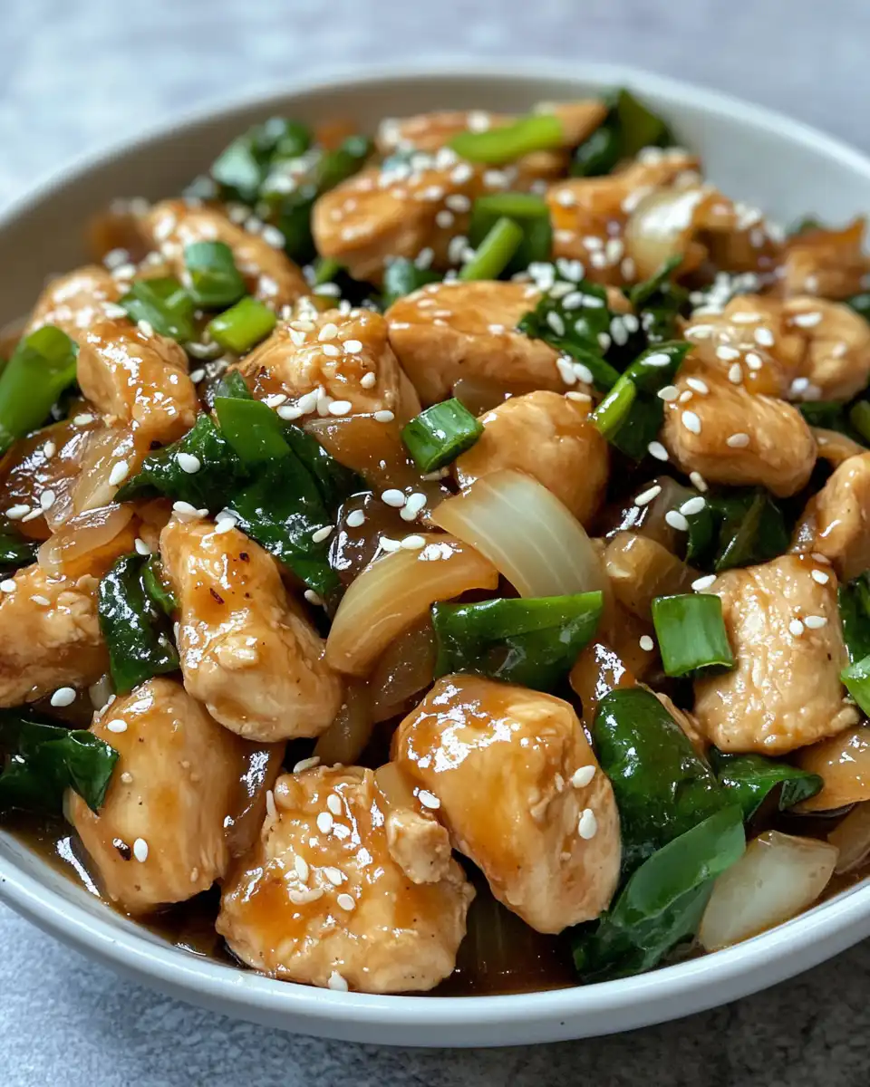 Ingredients including chicken, onions, garlic, and sauces ready to cook